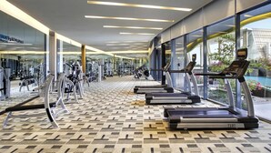 A gym with treadmills, weight machines, and a patterned floor. - Novotel Lampung (Bandar Lampung)