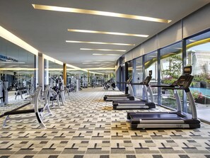 A gym with treadmills, weight machines, and a patterned floor.