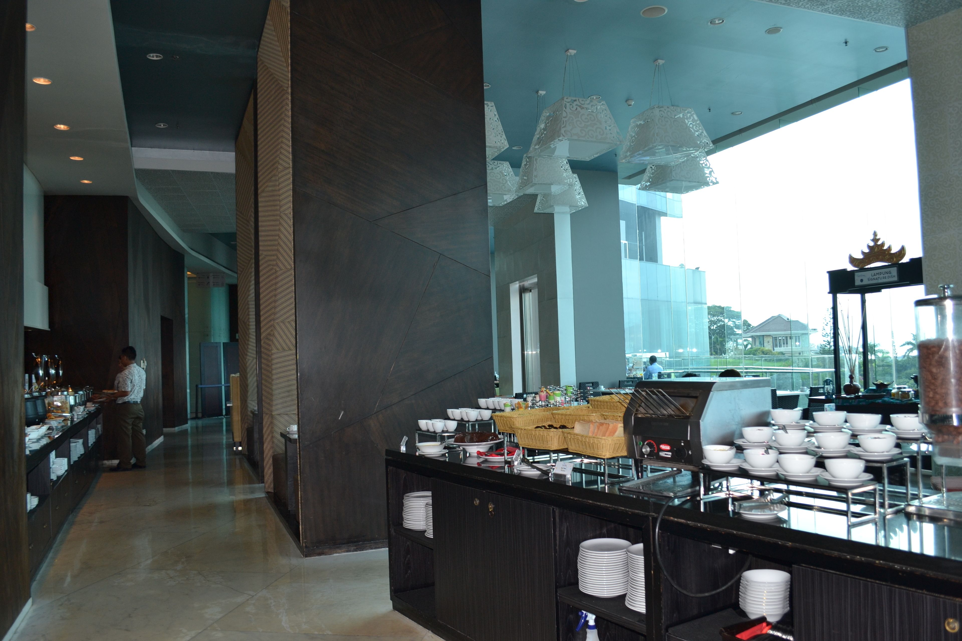 Een hotellobby met een buffetgedeelte, een bar en uitzicht over de stad.