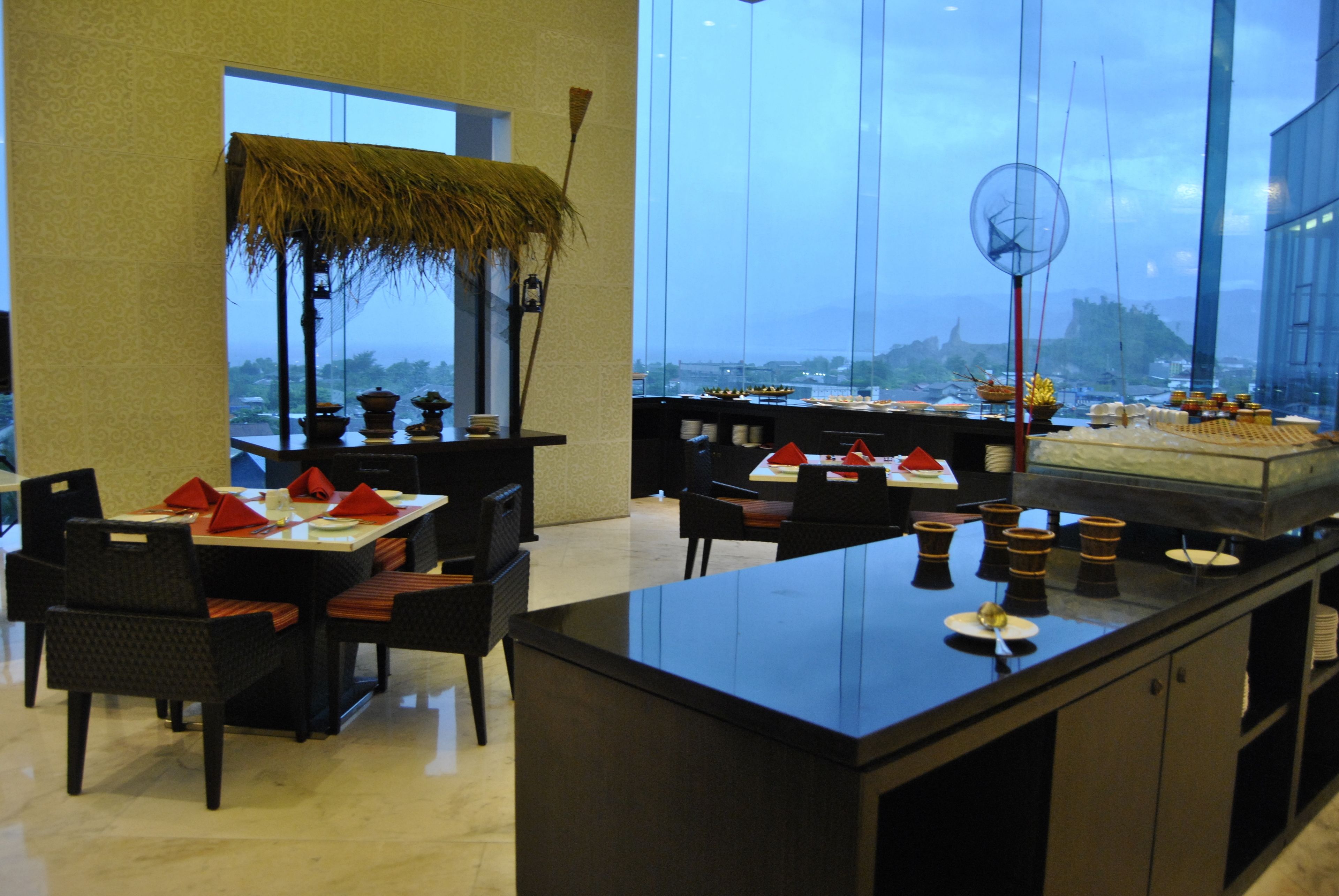 Un restaurante con una isla central, mesas y sillas para comer.