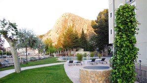 A courtyard with a pool, lounge chairs, and a stone fountain. - Hotel Balneario Alhama de Aragon (Alhama de Aragon)