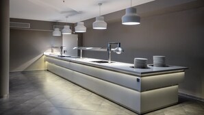 A modern, well-lit buffet area with a long counter, multiple serving stations, and overhead pendant lighting. - Hotel Balneario Alhama de Aragon (Alhama de Aragon)