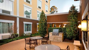 A courtyard with outdoor seating, a grill, and a well-maintained garden.