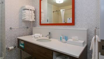 A modern bathroom with a white sink, a mirror with a red frame, and a towel rack.