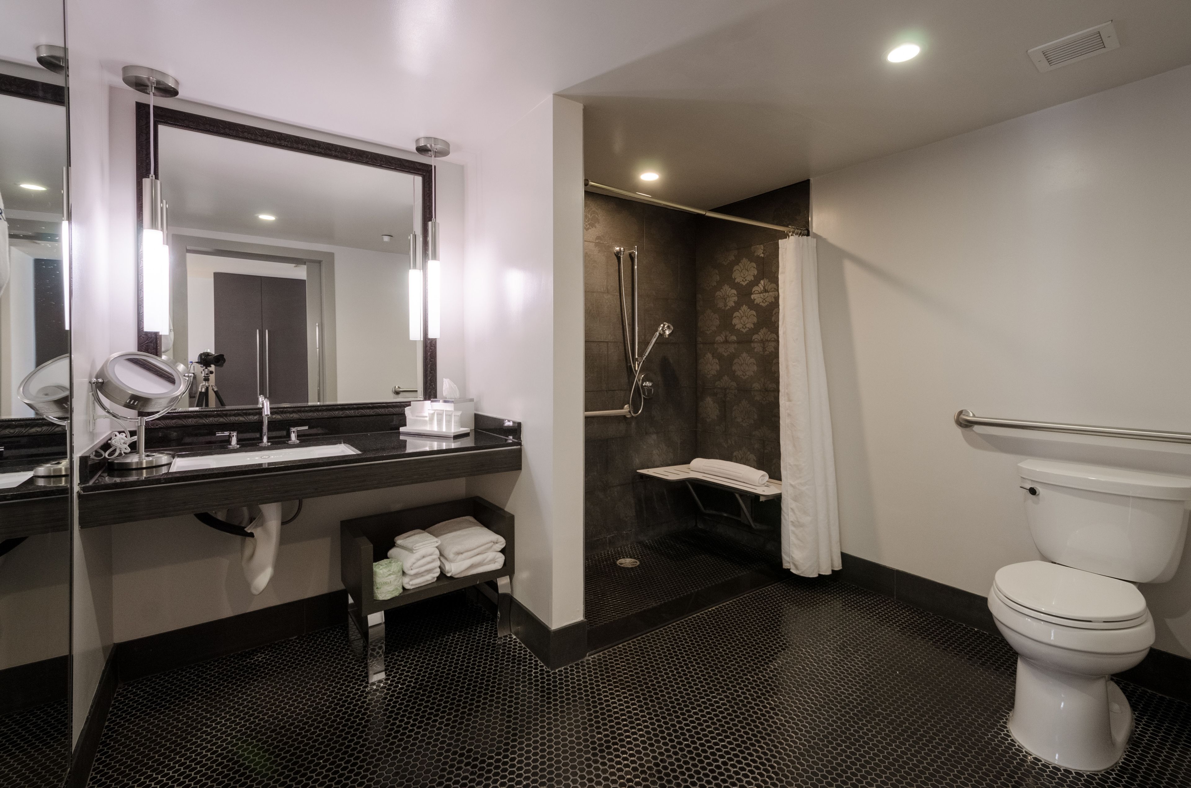 A modern bathroom with a glass-enclosed vanity, a separate shower area, and a toilet.