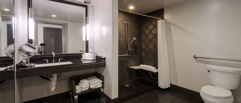 A modern bathroom with a glass-enclosed vanity, a separate shower area, and a toilet.