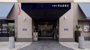 The entrance to The Padre Hotel with a dark awning, American flag, and a signboard.