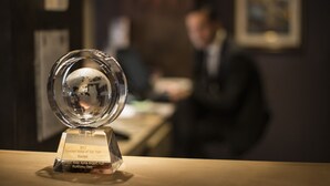 A clear glass trophy on a table with a plaque indicating it is for the Comfort Hotel of the Year 2011 in Europe. - Rome Airport Hotel Fiumicino (Fiumicino)
