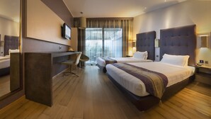 A hotel room with a large bed, a desk, and a TV. - Rome Airport Hotel Fiumicino (Fiumicino)