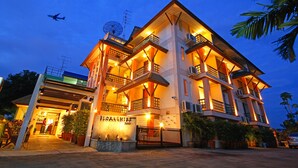 A multi-story hotel with balconies, a gated entrance, and a sign reading "Florashire." - Floral Shire Resort (Bangkok)