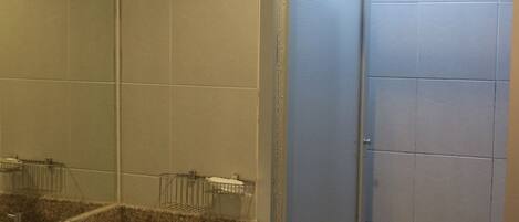 A bathroom with a sink, mirror, and shower.