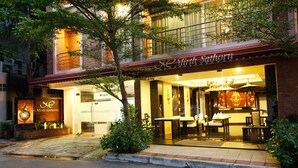 A restaurant with a sign reading "Mirth Sathorn" and outdoor seating visible through the windows. - Mirth Sathorn Hotel (Bangkok)