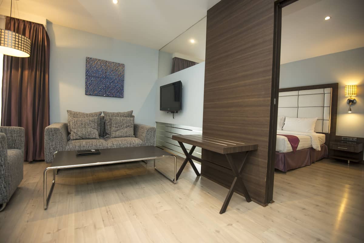 Ein modernes Wohnzimmer mit einer Couch, einem Couchtisch und einem an der Wand befestigten Fernseher.