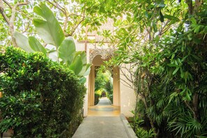 A pathway leading through a lush garden with a central water feature and an ornate archway. - Siripanna Villa Resort & Spa Chiang Mai (Chiang Mai)