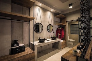 A modern bathroom with a large mirror, two sinks, and a wooden vanity.