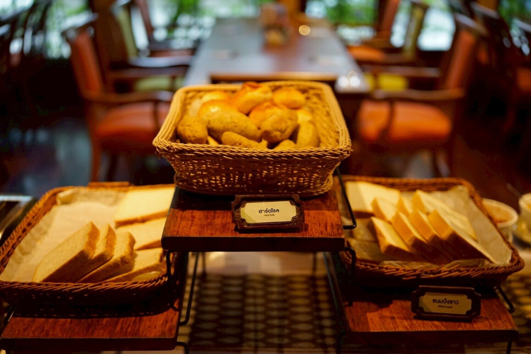 A buffet table with baskets of bread and a sign that reads "Baguette".
