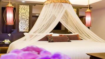 A bedroom with a canopy bed, two bedside lamps, and a decorative wall panel.