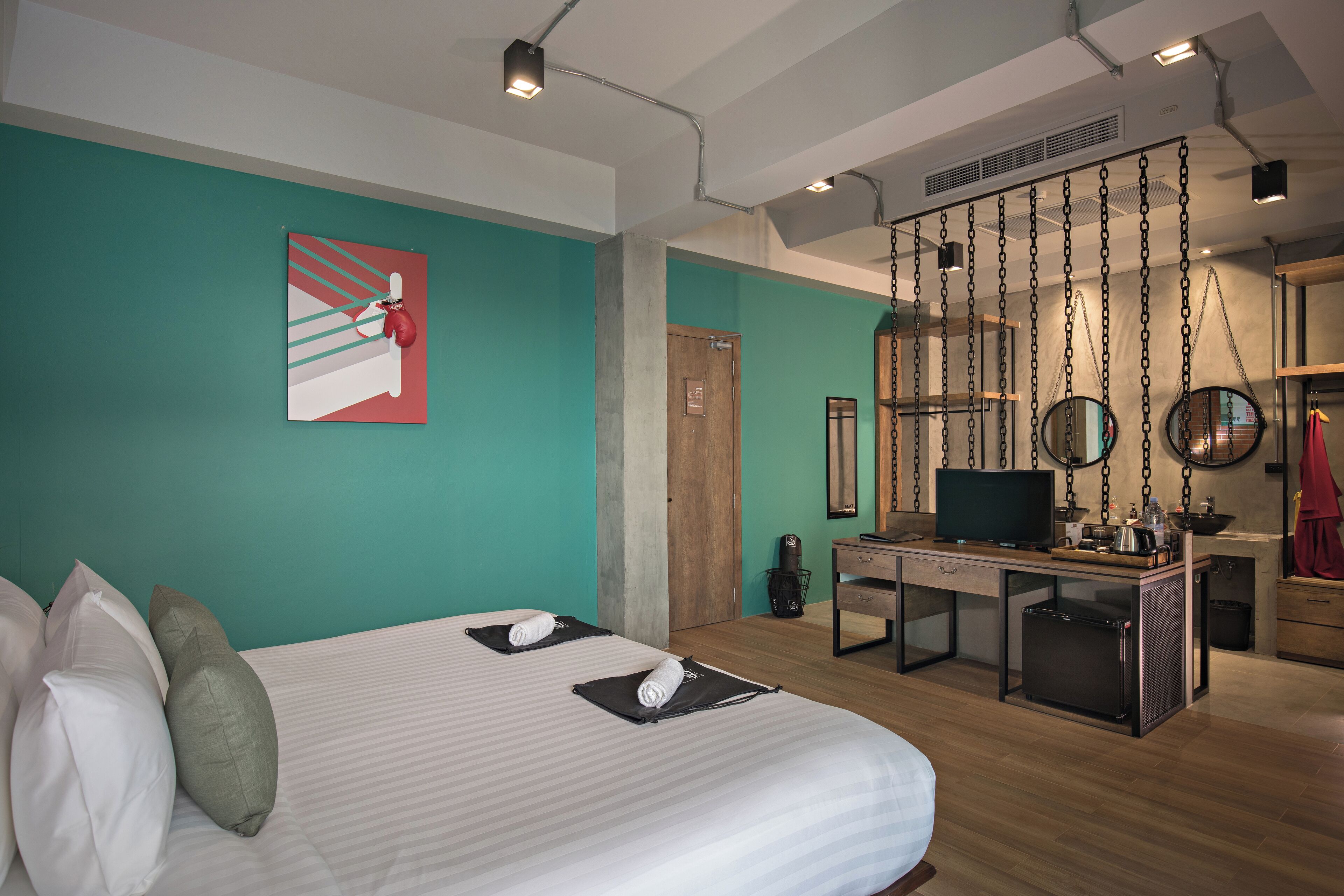 Una habitación de hotel con cama, escritorio con televisor y baño.