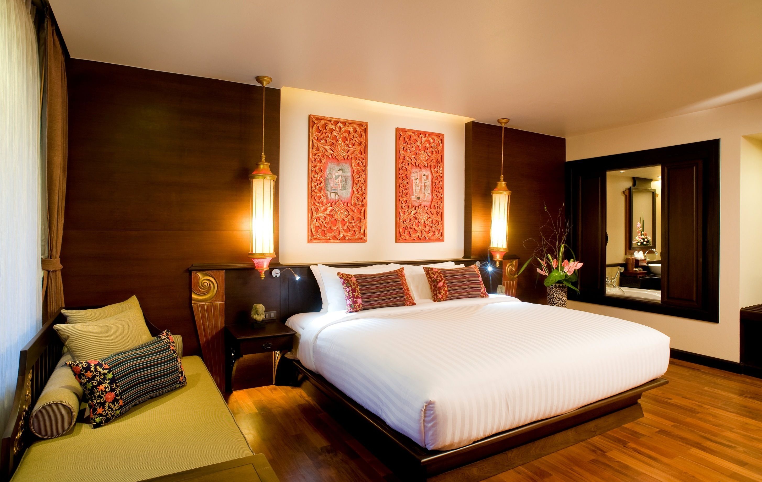 A spacious bedroom with a large bed, wooden headboard, and two wall-mounted lamps.