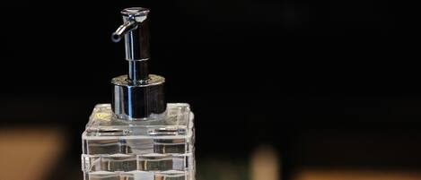 Una botella de gel hidroalcohólico con dosificador tipo bomba y un letrero que dice 'GEL DESINFECTANTE'.