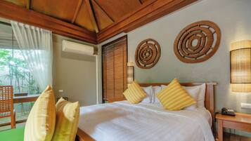 A hotel room with a large bed, wooden headboard, and two wall decor pieces.