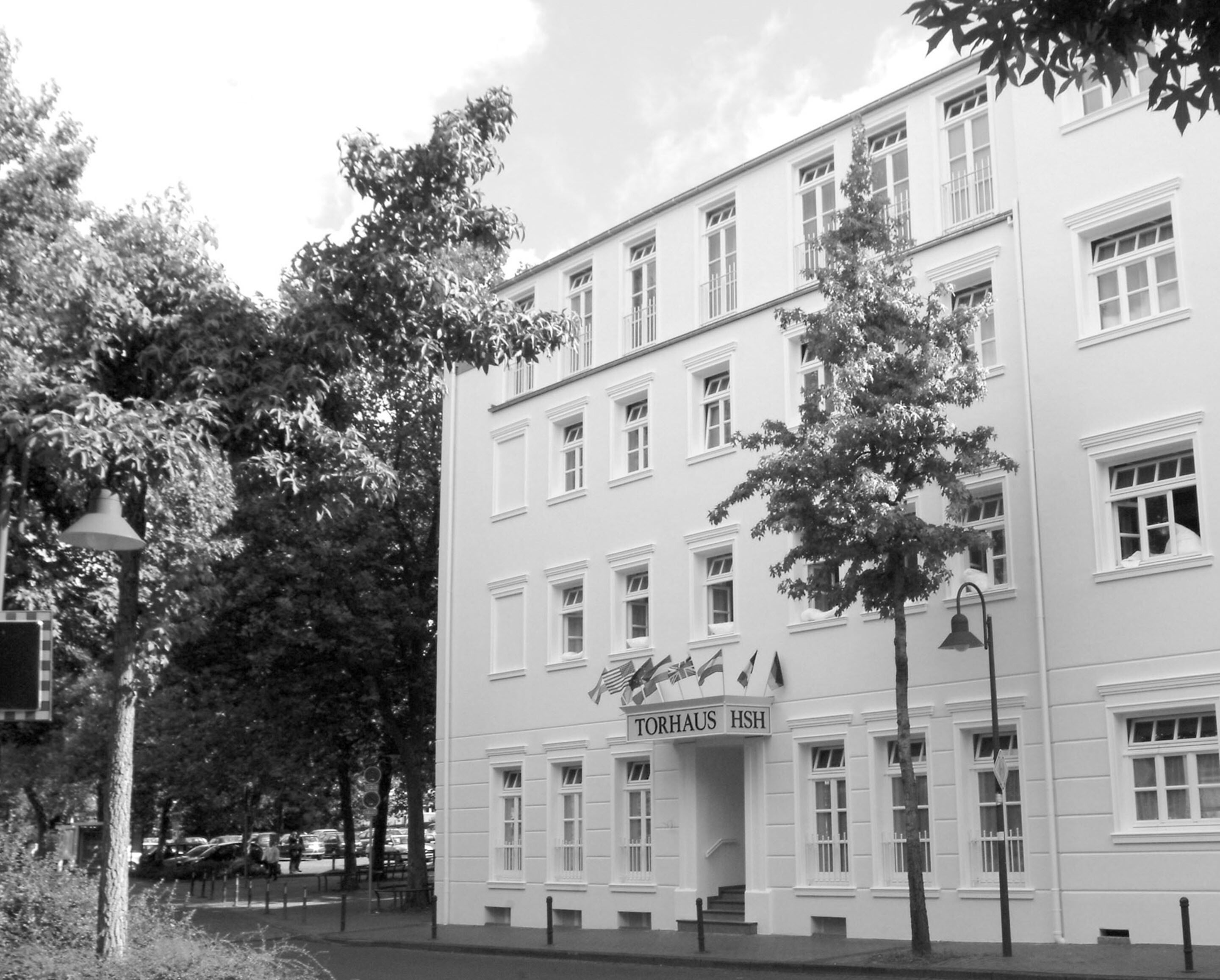 A multi-story building with a sign reading "TORHAUS HSH".