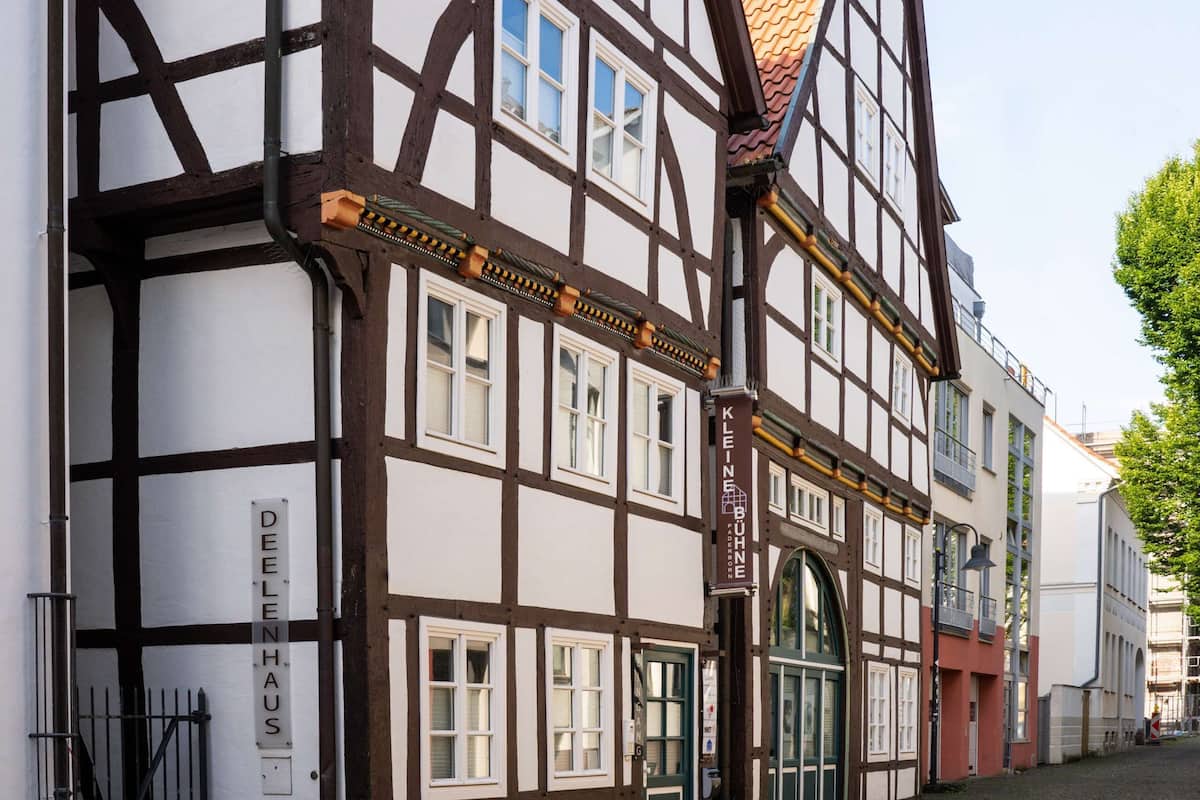 A traditional half-timbered building with a sign reading "DEELENHAUS".