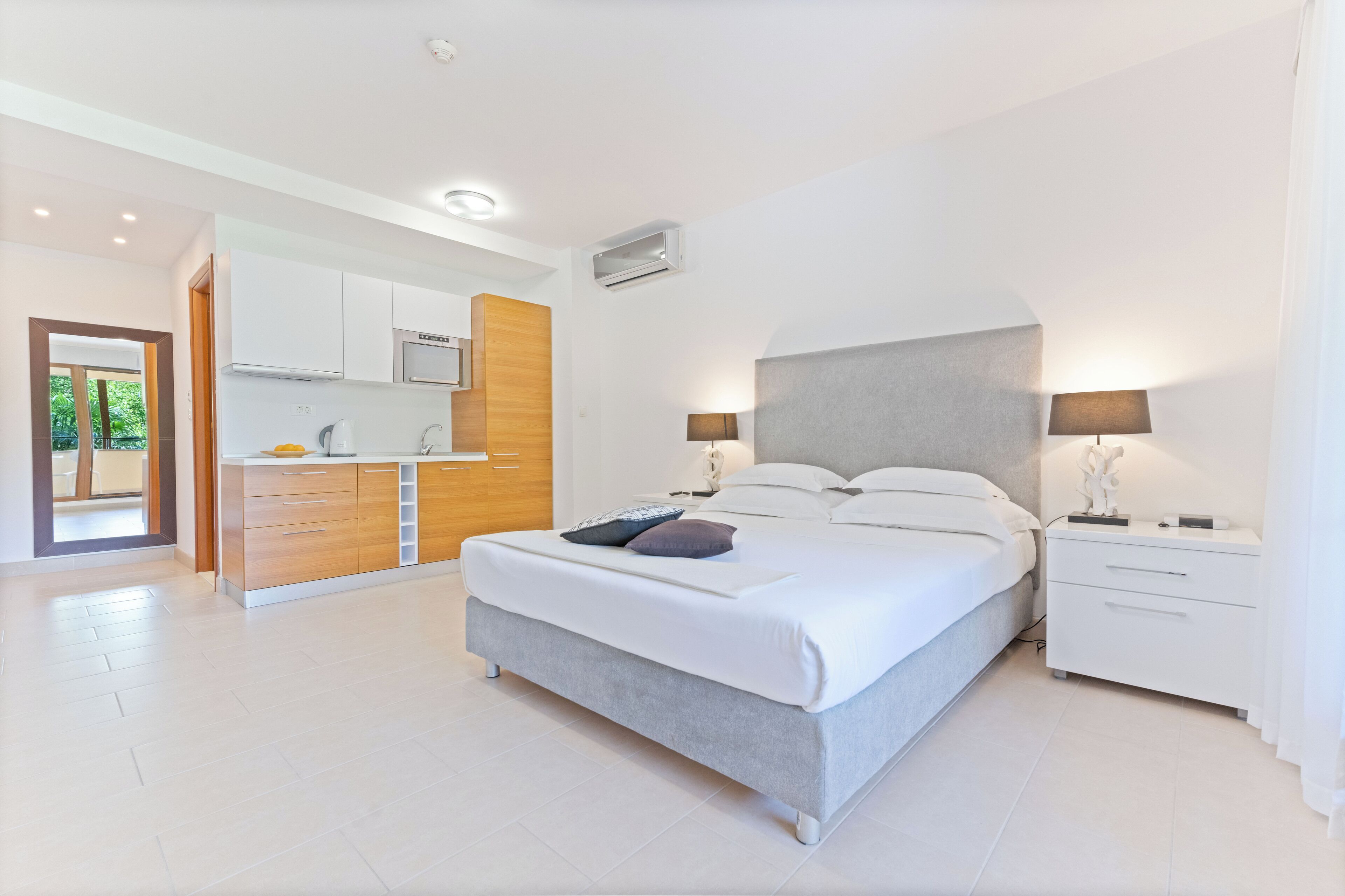 A modern bedroom with a large bed, bedside tables, and a built-in wardrobe.