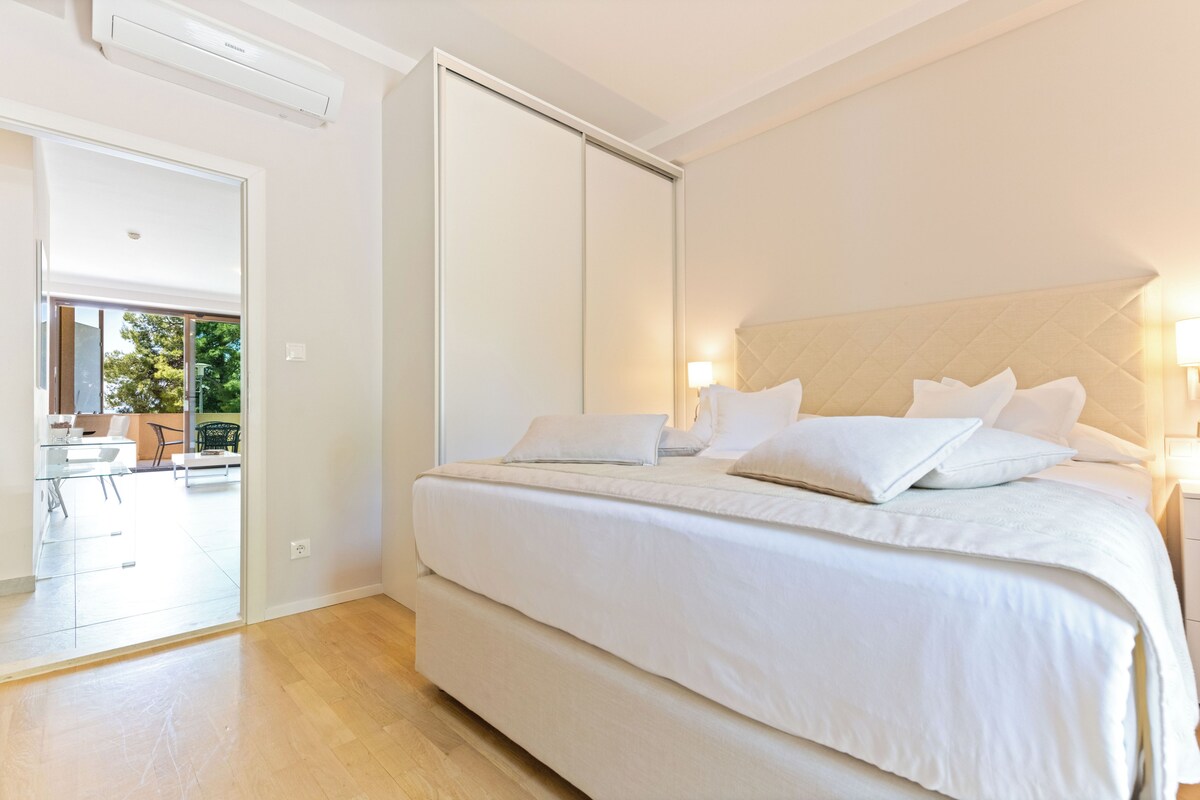 A bedroom with a large bed, a sliding door leading to a balcony, and a modern design.