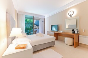 A modern hotel room with a bed, bedside table, lamp, and a television. - The Residence (Podstrana)
