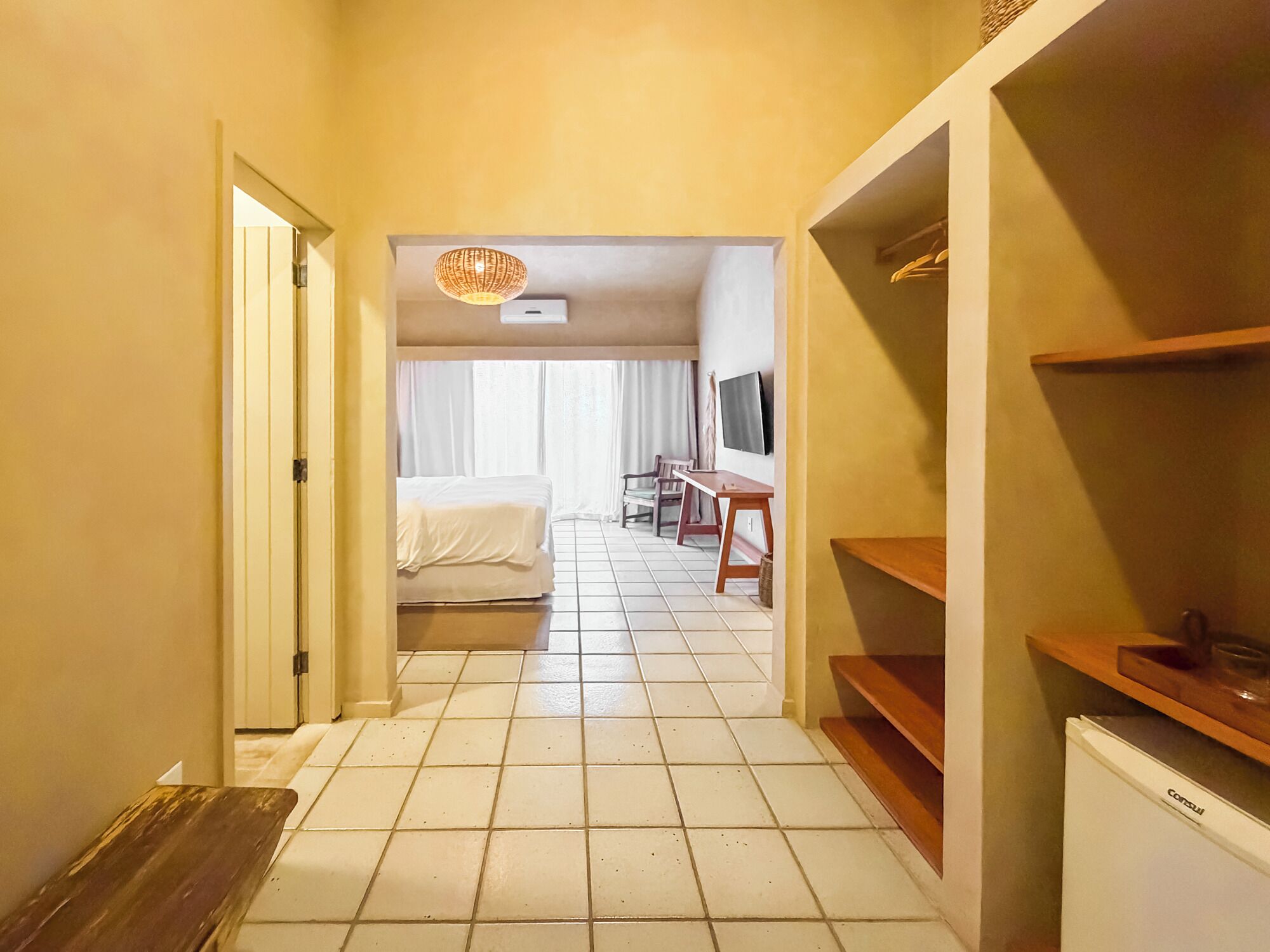 Habitació d'hotel amb llit, escriptori, televisió i cuineta.