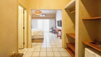 Habitació d'hotel amb llit, escriptori, televisió i cuineta.