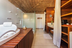 Un baño moderno con bañera, tocador de madera, espejo y zona de ducha.
