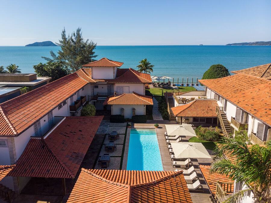 Un resort con piscina, zona de estar al aire libre y vistas al mar.