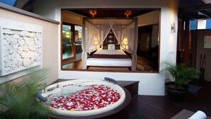 Un dormitorio con una cama grande, un baño con paredes de cristal y una pared decorativa.