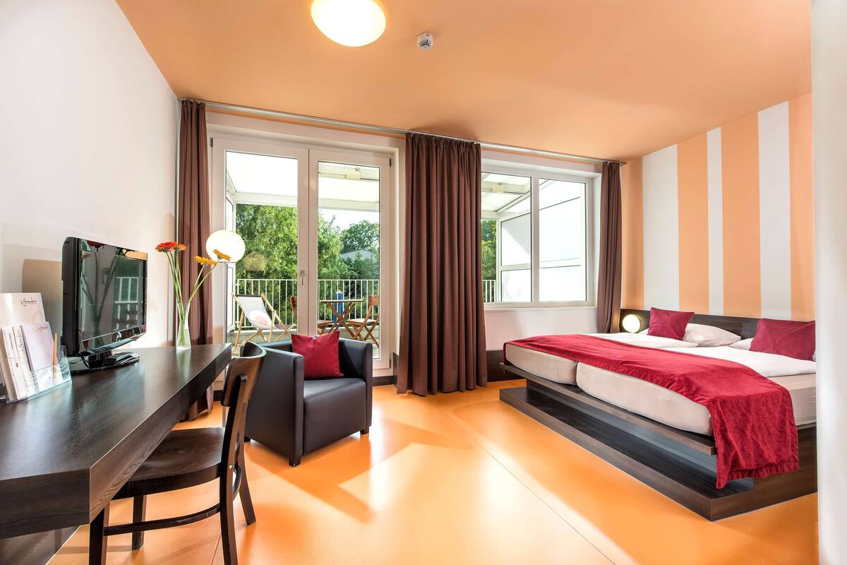 Una habitación de hotel moderna con una cama, un escritorio y una silla.