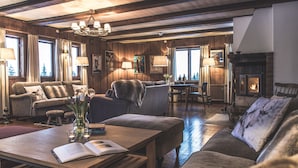Uma sala de estar aconchegante com lareira, móveis de madeira e vista para o exterior.