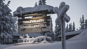 Um sinal coberto de neve com o texto "Trillevallens Höglhallshotell".