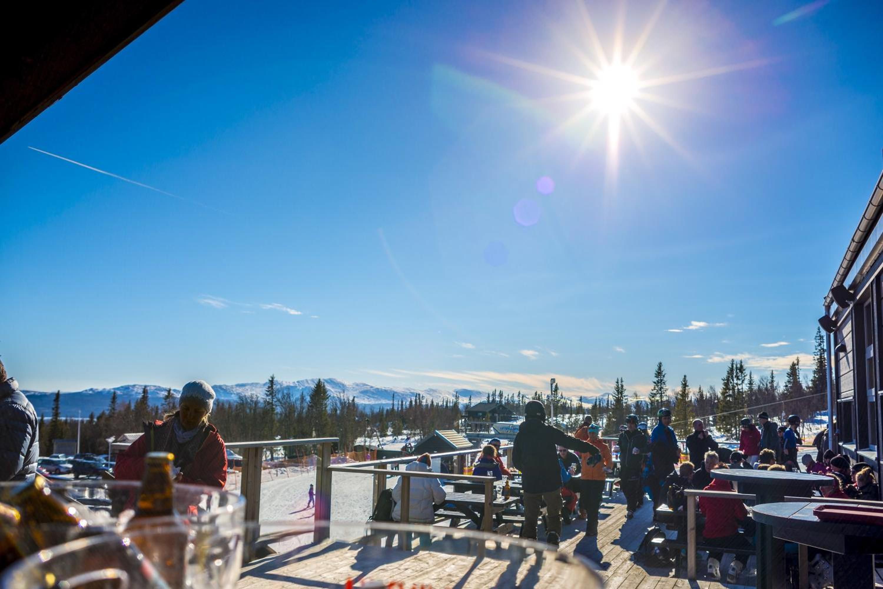 An outdoor seating area with a view of snow-capped mountains and a clear sky.