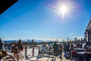 An outdoor seating area with a view of snow-capped mountains and a clear sky. - Trillevallen Högfjällshotell (Undersaker)