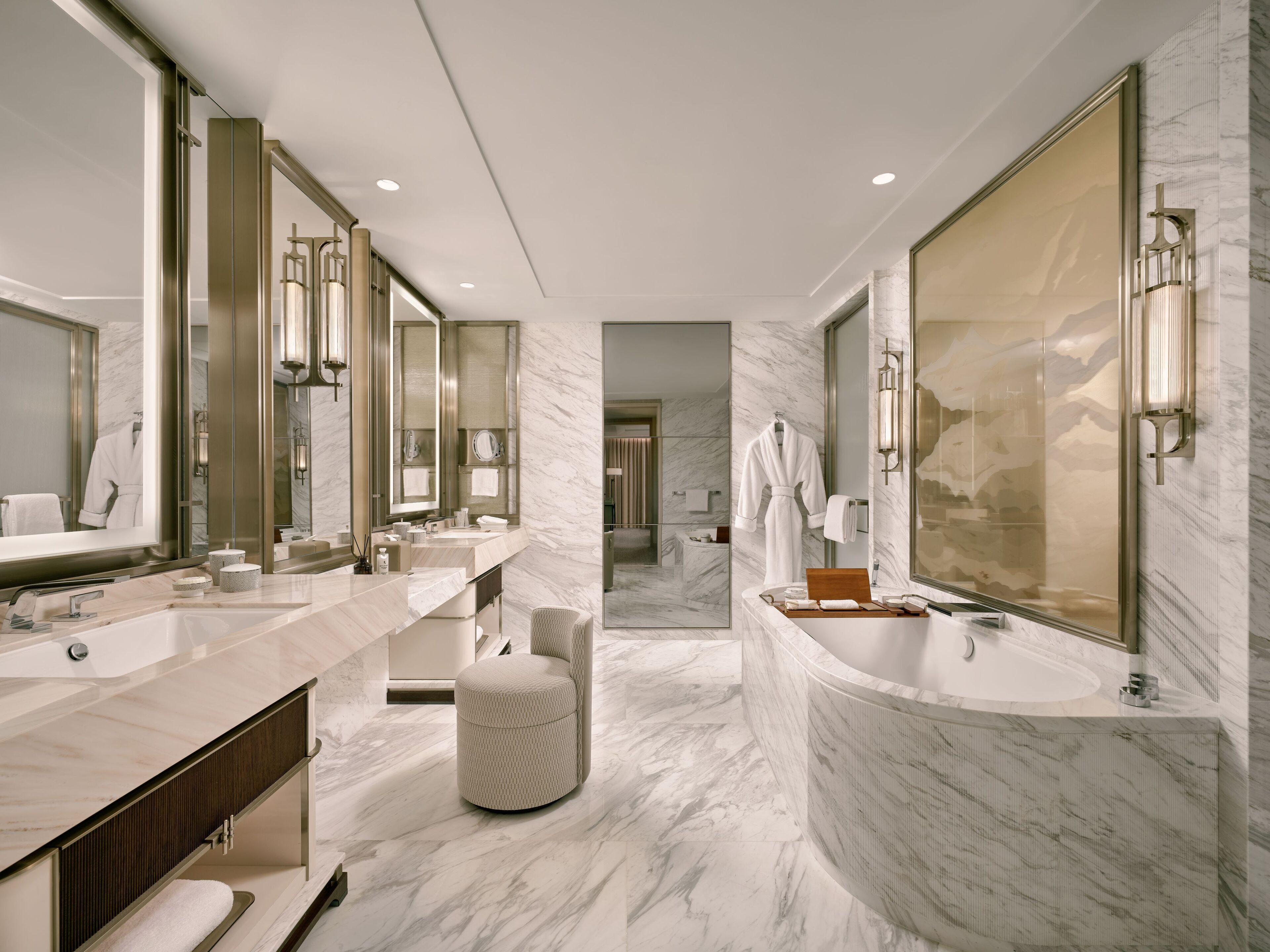 A modern bathroom with two sinks, a large mirror, and a bathtub.