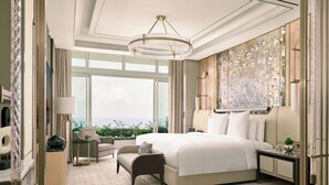Una habitación de hotel moderna con una cama grande, un área de descanso, un escritorio y vistas a la ciudad.
