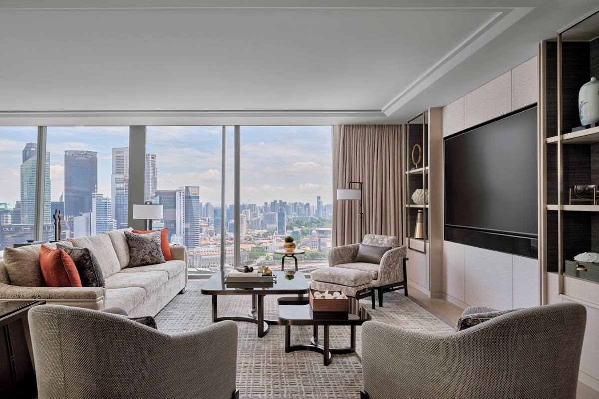 A modern living room with a city view, a flat-screen TV, and a comfortable seating area.