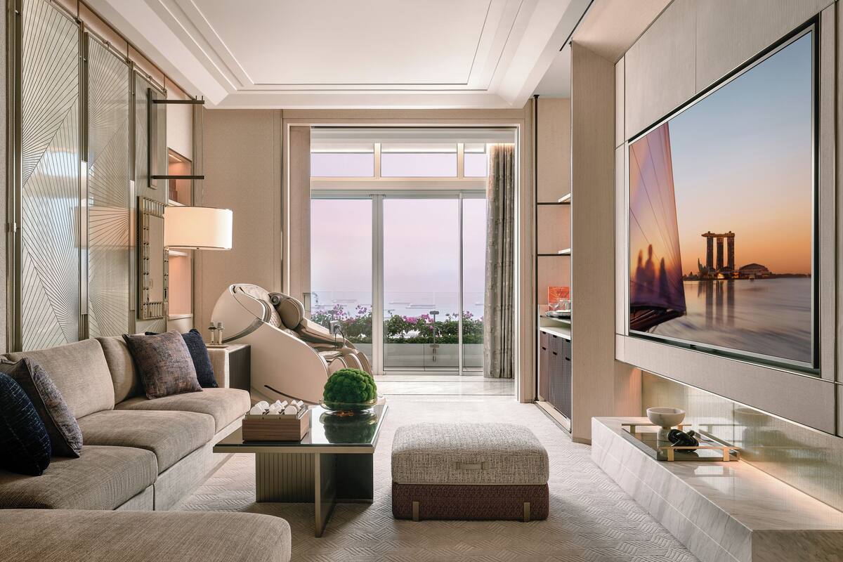 A modern living room with a sofa, a coffee table, and a flat-screen TV mounted on the wall.