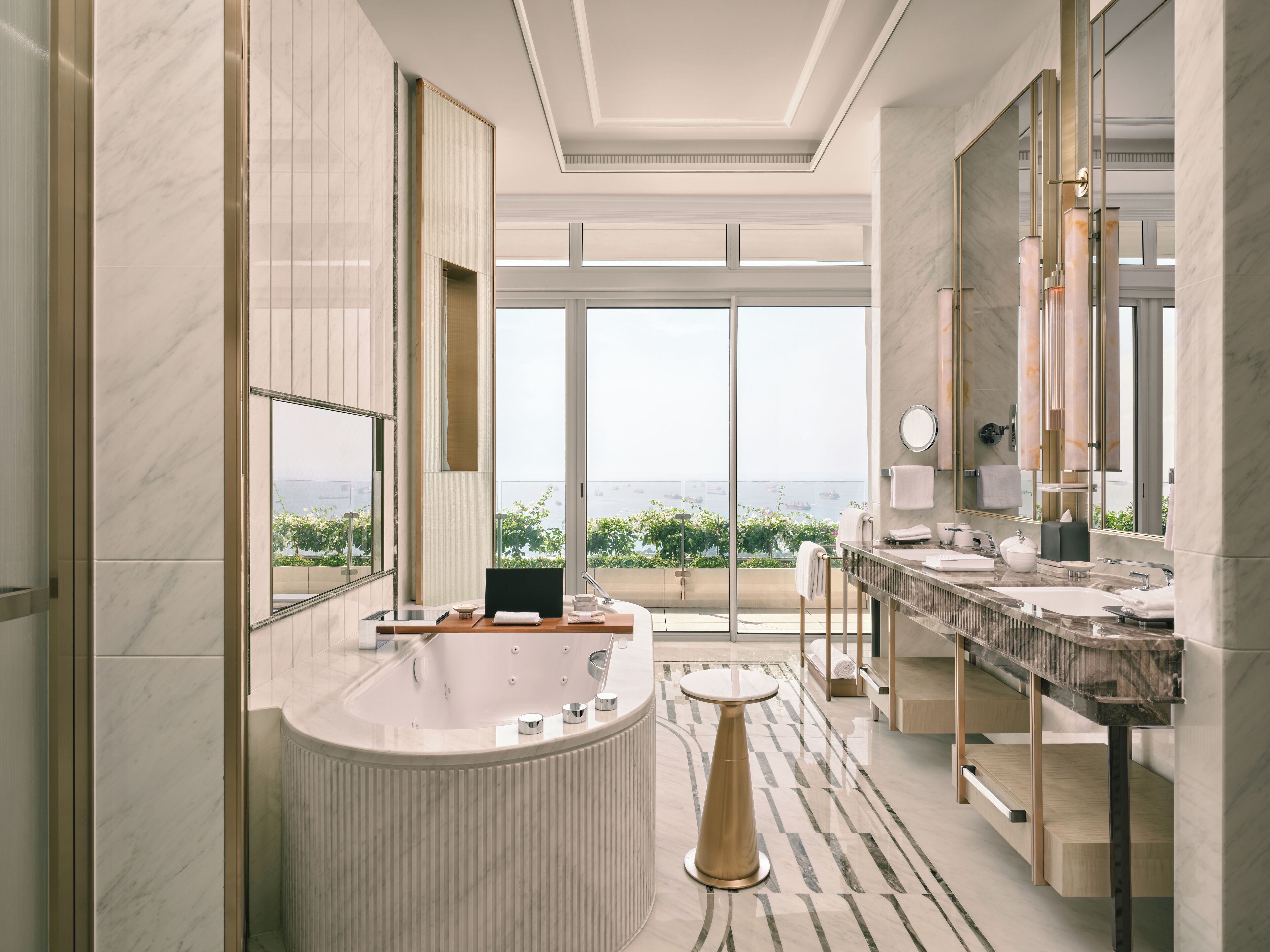 A modern bathroom with a large bathtub, a vanity with a sink, and a large mirror.