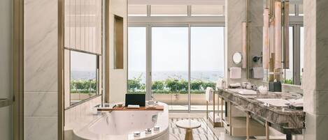 A modern bathroom with a large bathtub, a vanity with a sink, and a large mirror.