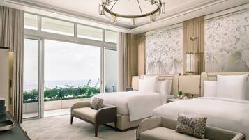 A hotel room with a large bed, a smaller sofa, a desk, and a view of the city.