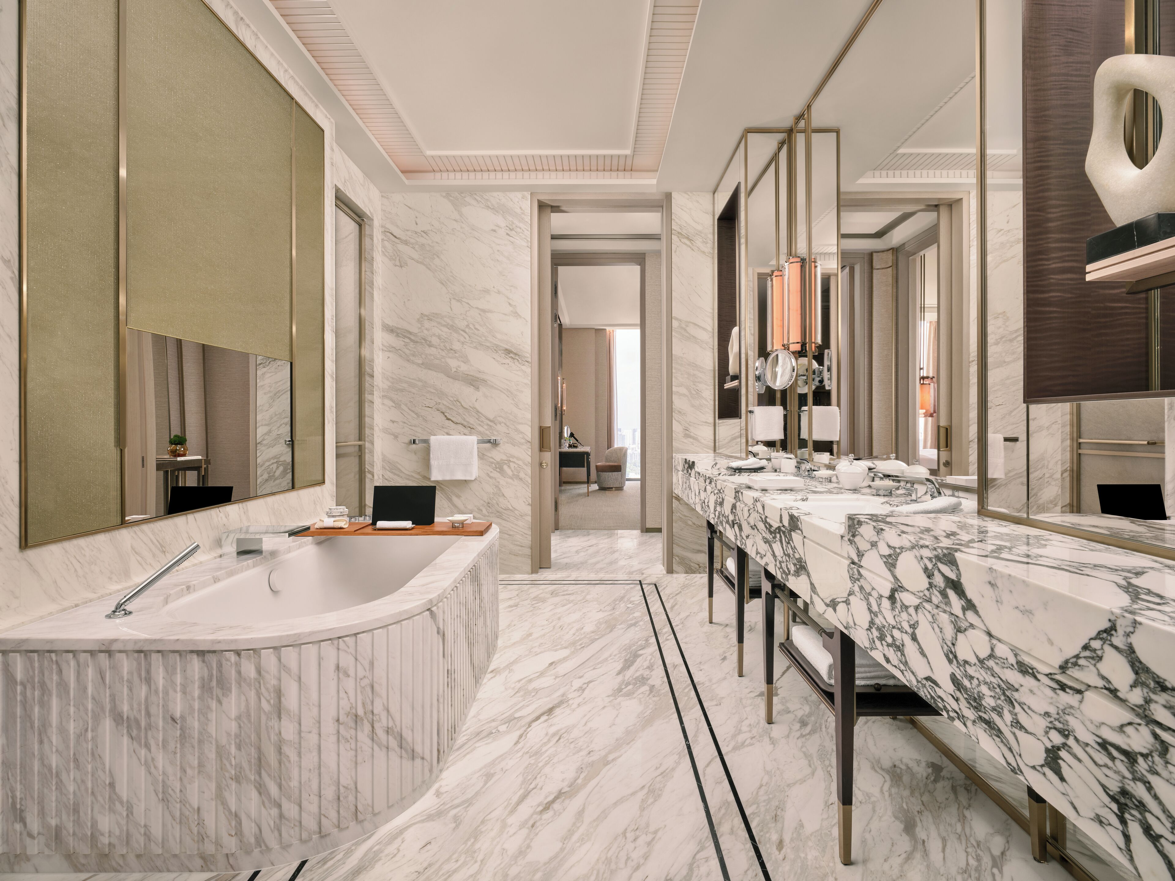 Moderni kylpyhuone, jossa on suuri kylpyamme, kaksi pesuallasta ja erillinen suihkutila.