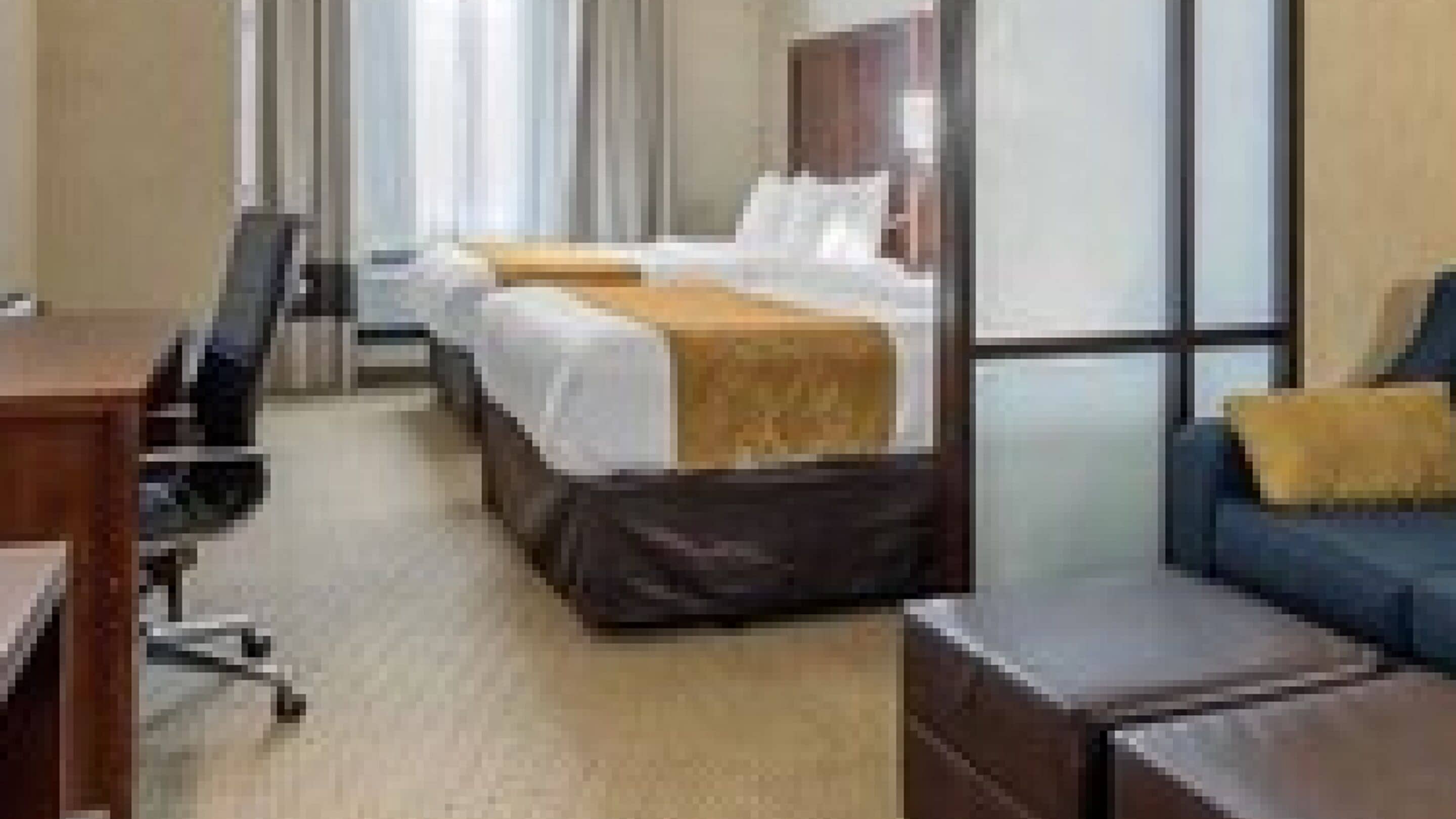 A hotel room with two beds, a desk, and a chair.