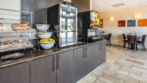 A hotel breakfast area with a self-service station, seating area, and a view of the outside. - Comfort Suites Near City of Industry - Los Angeles (La Puente)